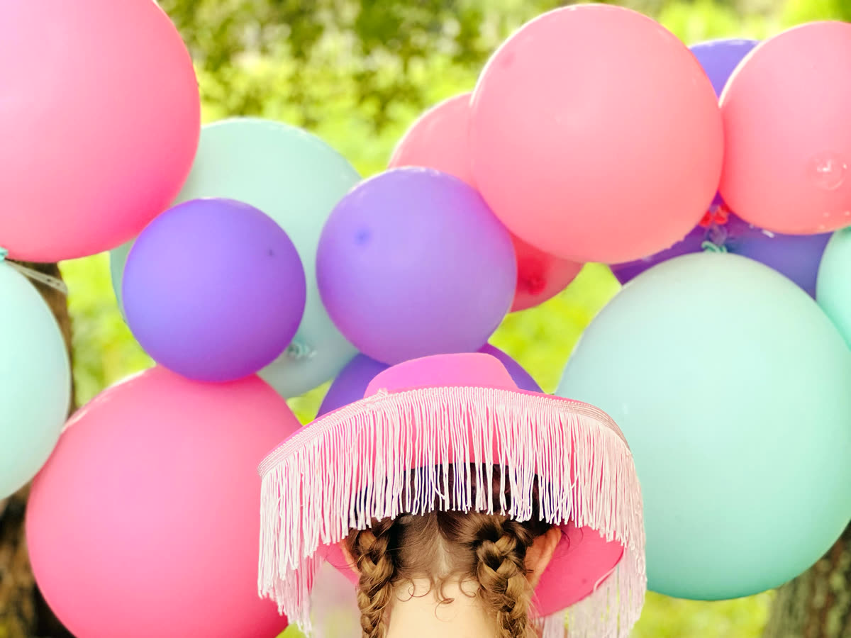 A pastel balloon arch in pink, purple and mint at a pony party